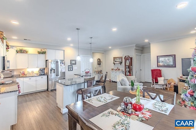 dining area featuring sink, crown molding, and light hardwood / wood-style flooring