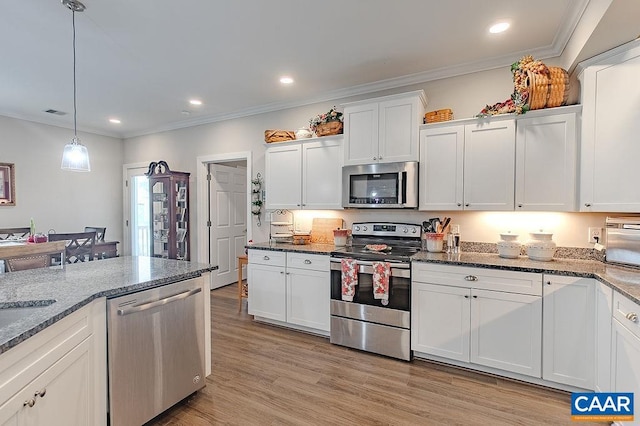 kitchen with light hardwood / wood-style flooring, white cabinets, pendant lighting, and appliances with stainless steel finishes