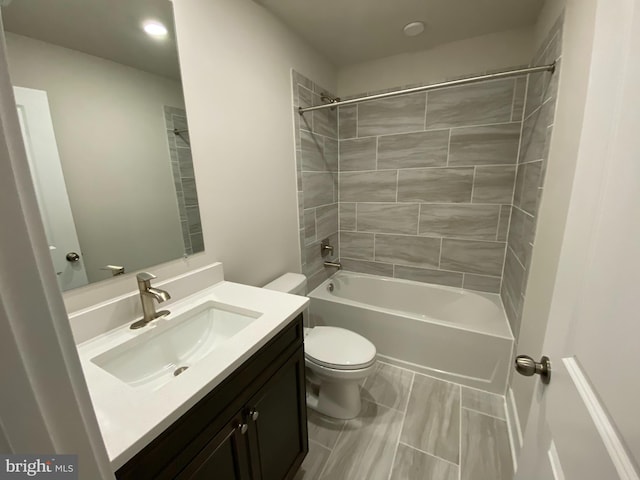 full bathroom with vanity, tiled shower / bath combo, and toilet