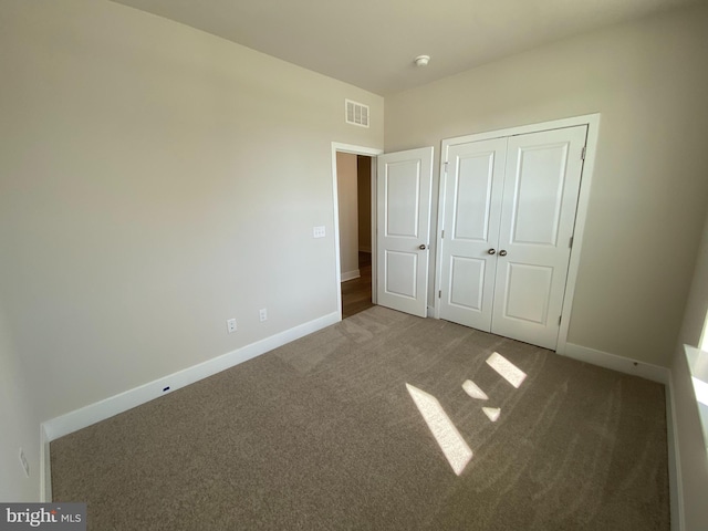 unfurnished bedroom featuring carpet flooring and a closet