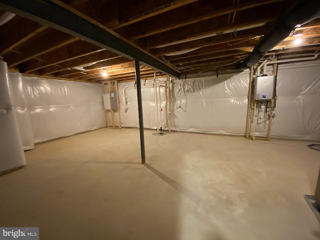 basement featuring electric panel and water heater