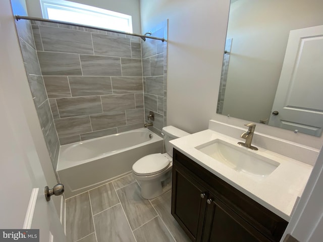 full bathroom featuring vanity, tiled shower / bath combo, and toilet