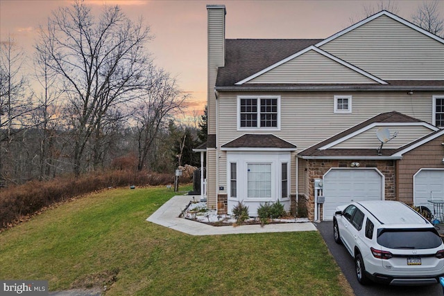 view of front of house featuring a lawn and a garage