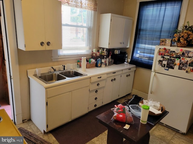 kitchen with white cabinets, white refrigerator, and sink