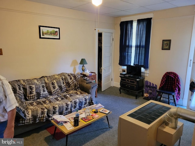 living room featuring carpet and a drop ceiling