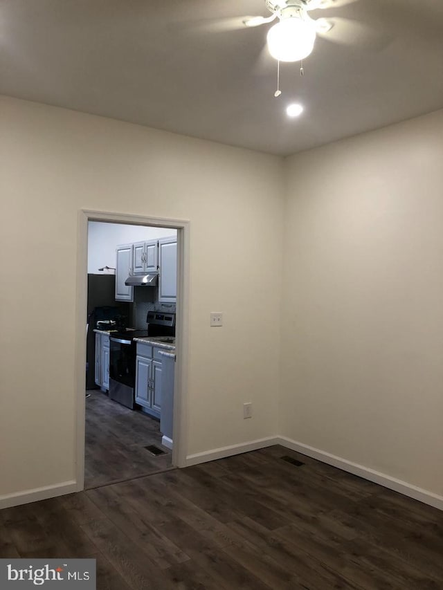 unfurnished room featuring ceiling fan and dark hardwood / wood-style flooring