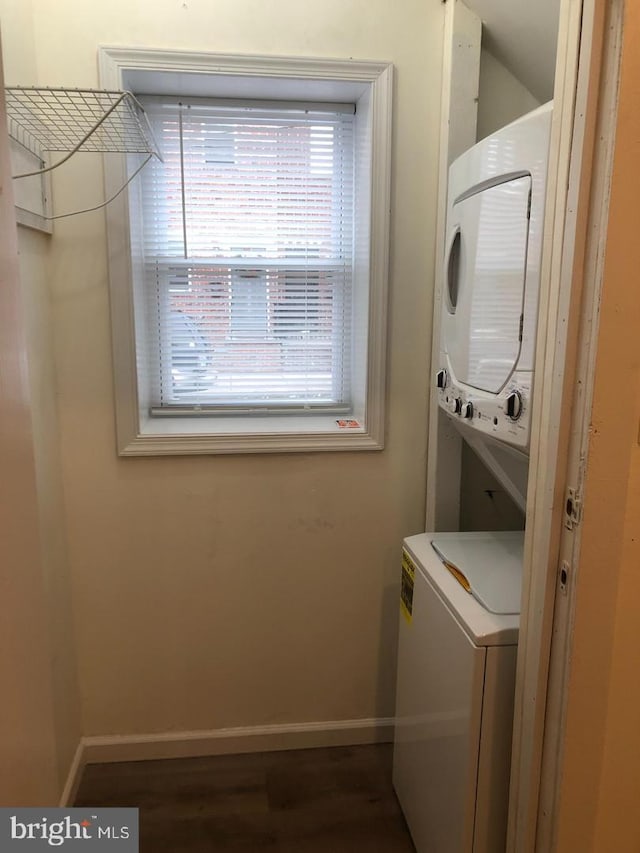 clothes washing area featuring stacked washer / dryer and hardwood / wood-style floors