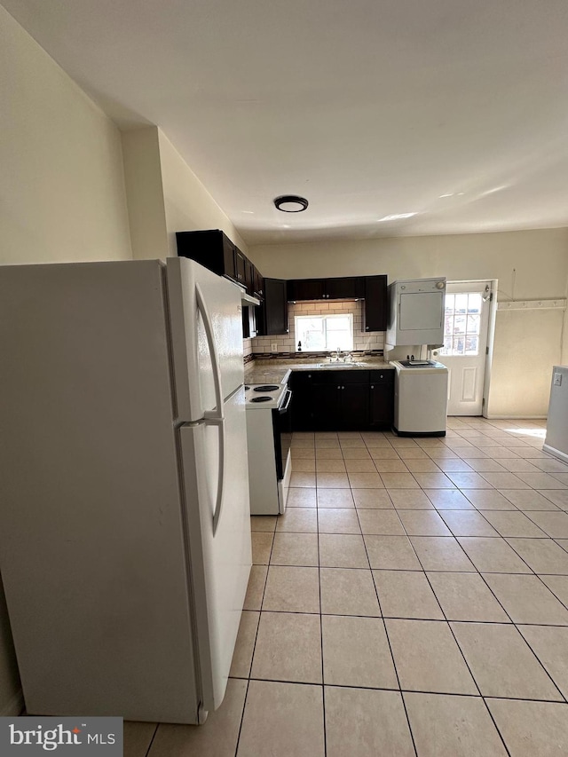 kitchen featuring white appliances, sink, light tile patterned floors, and tasteful backsplash