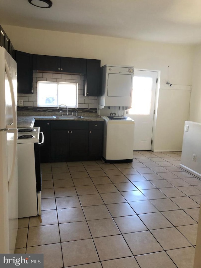 kitchen featuring white appliances, sink, decorative backsplash, light tile patterned floors, and washer / dryer