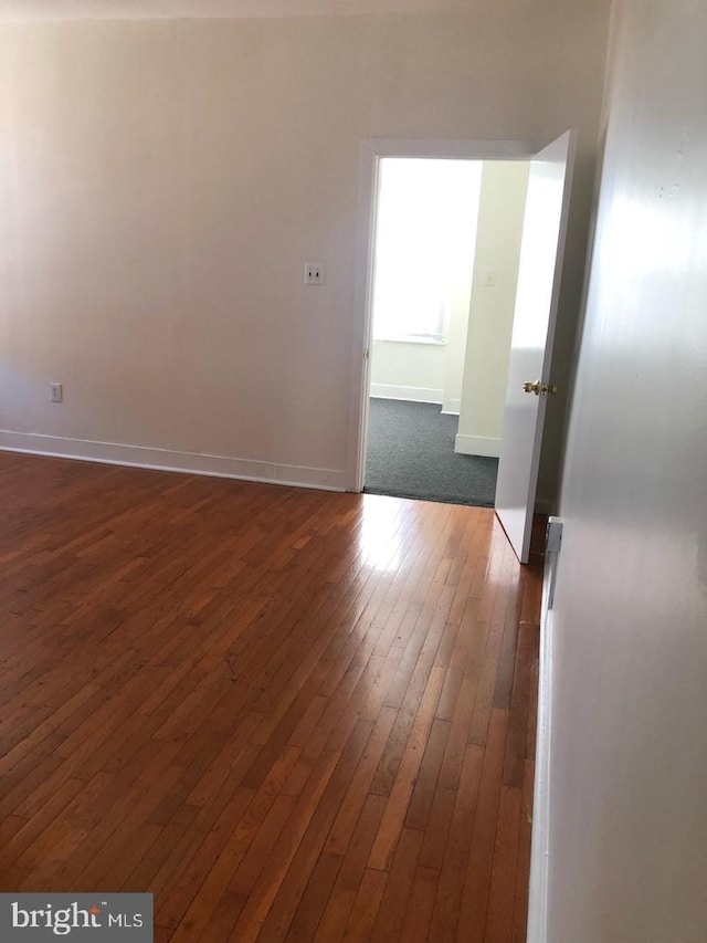 spare room featuring dark wood-type flooring