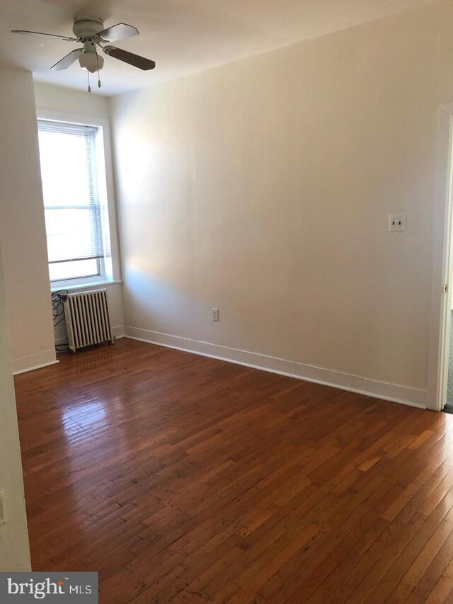 1600 S Taney St, Philadelphia, PA 19145 - unfurnished room featuring radiator, dark wood-type flooring, a ceiling fan, and baseboards