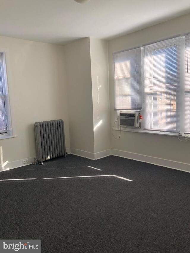 1600 S Taney St, Philadelphia, PA 19145 - empty room with radiator, baseboards, cooling unit, and dark colored carpet