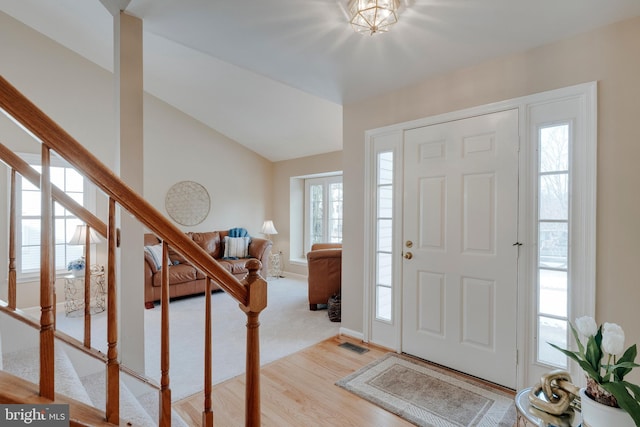 foyer entrance featuring lofted ceiling and light hardwood / wood-style floors