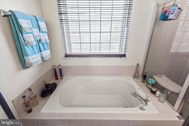 bathroom with a relaxing tiled tub