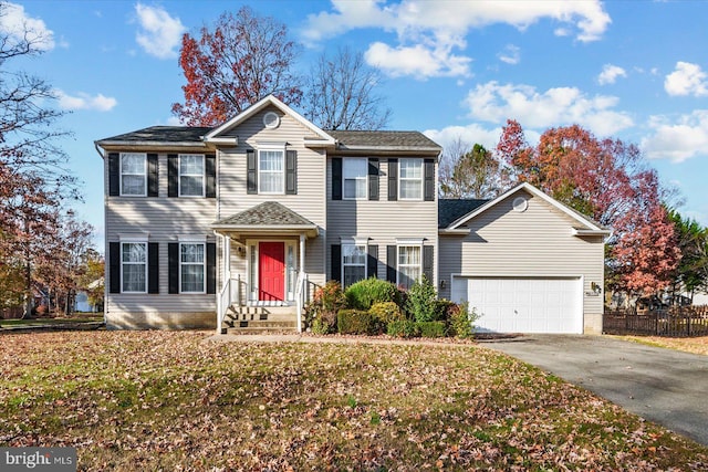 colonial home with a front lawn and a garage