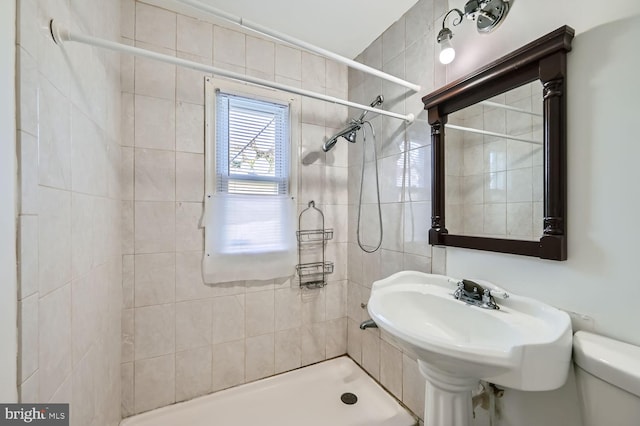 bathroom featuring toilet and tiled shower