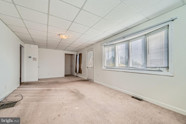 empty room with light carpet and a paneled ceiling