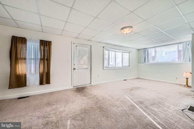 carpeted empty room with a paneled ceiling