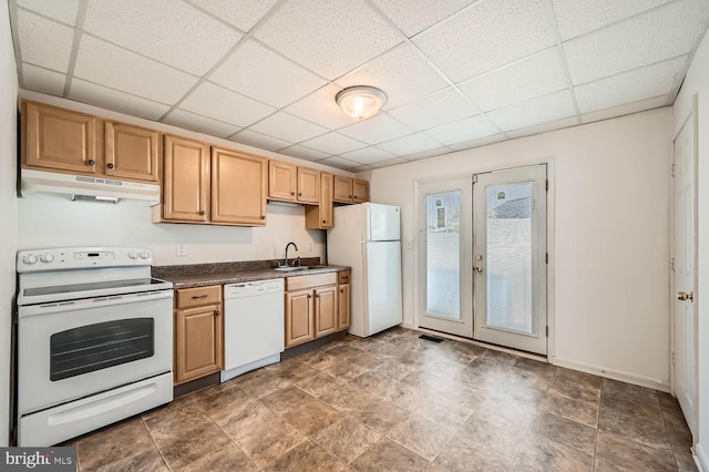 kitchen with light brown cabinetry, a drop ceiling, white appliances, and sink