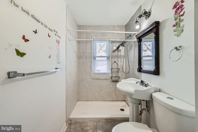 bathroom featuring tiled shower and toilet