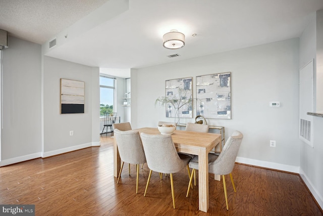 dining room featuring a textured ceiling and hardwood / wood-style flooring