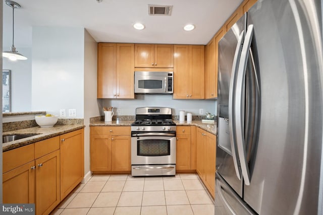 kitchen featuring pendant lighting, light tile patterned floors, light stone countertops, and appliances with stainless steel finishes