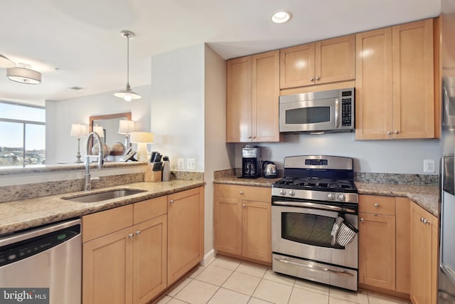 kitchen with appliances with stainless steel finishes, sink, light brown cabinets, light tile patterned floors, and hanging light fixtures