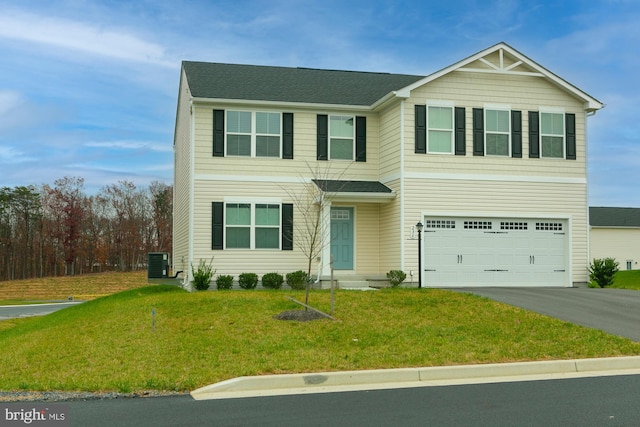 view of front of property with a front lawn, cooling unit, and a garage