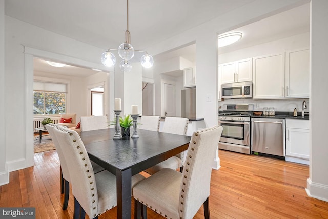 dining area with sink and light hardwood / wood-style floors