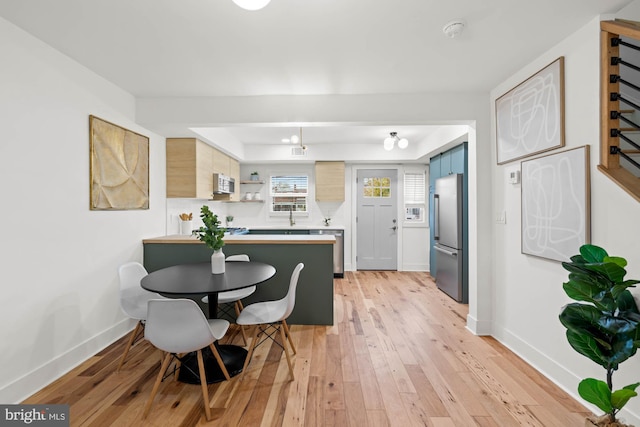 dining room with sink and light wood-type flooring