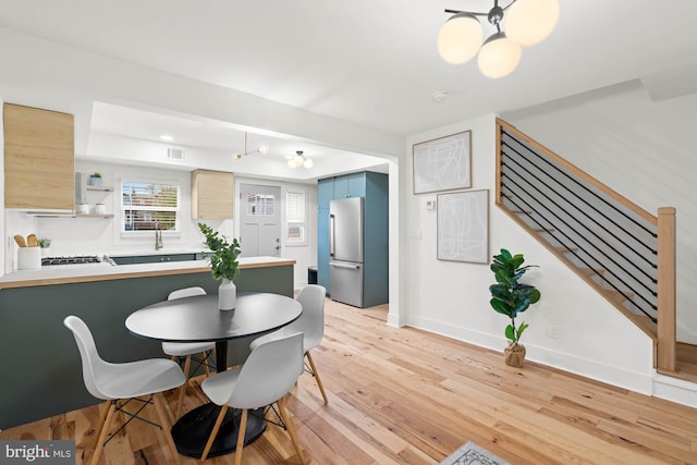 dining space featuring sink and light hardwood / wood-style floors