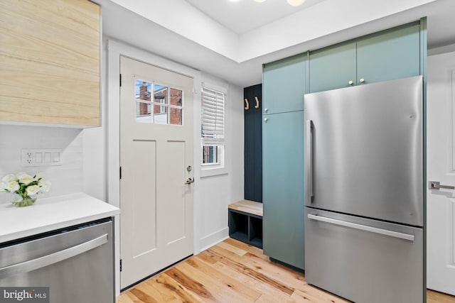 kitchen with stainless steel appliances, tasteful backsplash, and light hardwood / wood-style floors