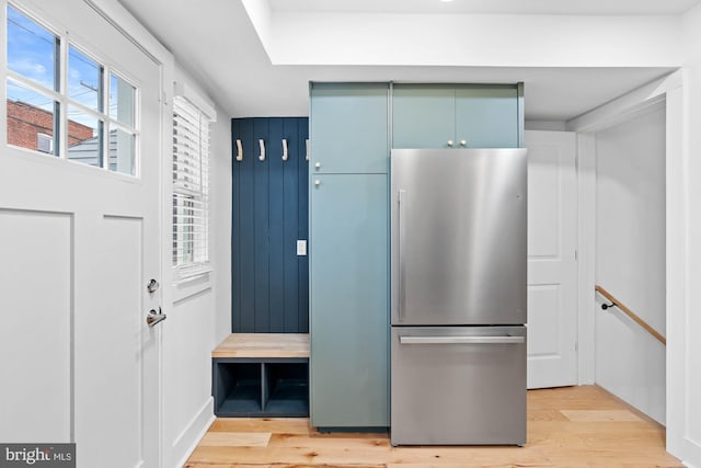 kitchen with stainless steel fridge and light hardwood / wood-style floors