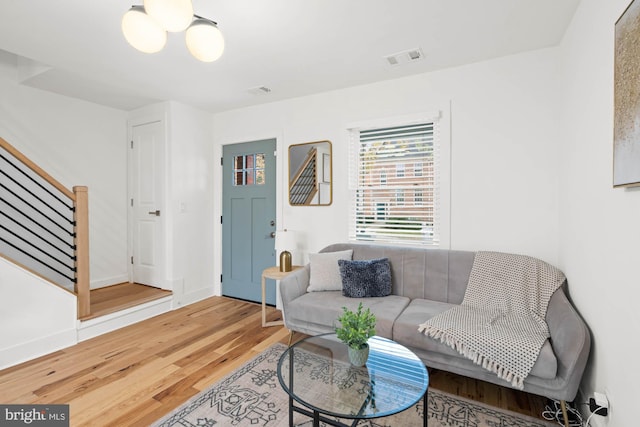 living room with hardwood / wood-style floors and an inviting chandelier