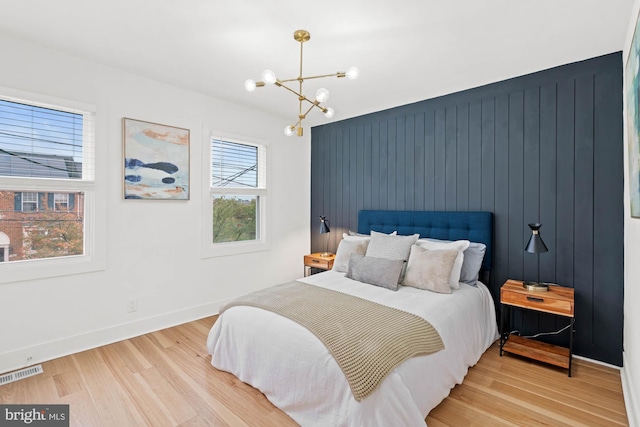 bedroom featuring a chandelier and light hardwood / wood-style flooring