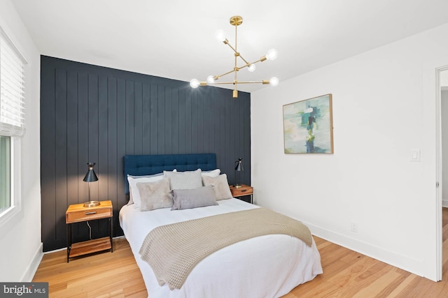 bedroom featuring hardwood / wood-style flooring, wood walls, and an inviting chandelier