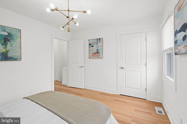 bedroom featuring a chandelier and hardwood / wood-style floors