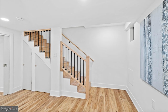 stairway with hardwood / wood-style flooring