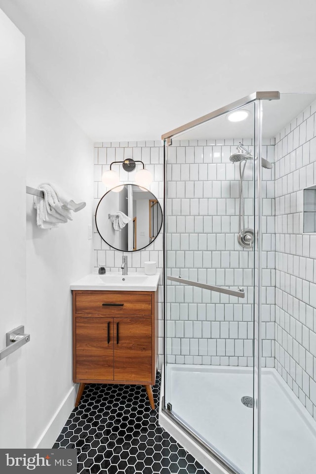 bathroom with tile patterned flooring, vanity, and a shower with door