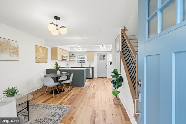 foyer featuring a chandelier, sink, and light hardwood / wood-style flooring