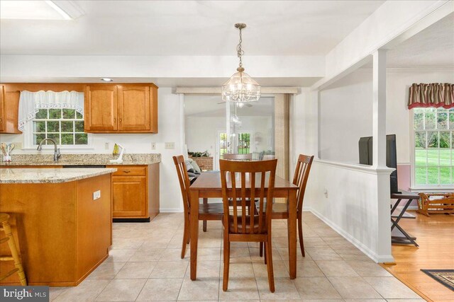 dining room featuring plenty of natural light, light tile patterned floors, and an inviting chandelier