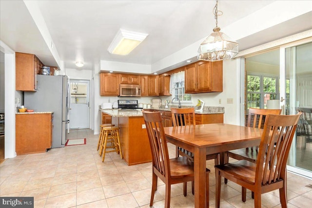 tiled dining space with sink, a wealth of natural light, and a chandelier