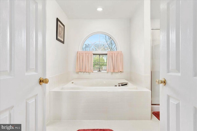 bathroom featuring a relaxing tiled tub