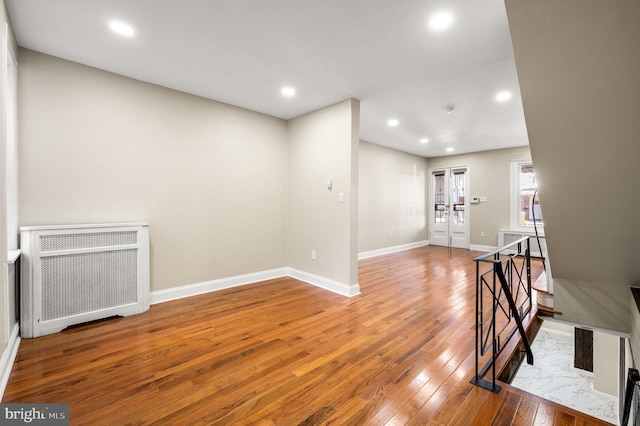 spare room featuring hardwood / wood-style flooring and radiator heating unit