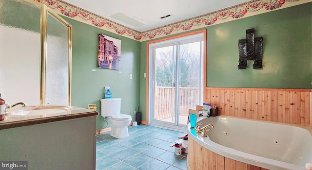 bathroom featuring a tub, tile patterned flooring, wood walls, toilet, and vanity