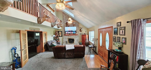 living room with hardwood / wood-style floors, high vaulted ceiling, ceiling fan, and a wealth of natural light