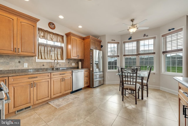 kitchen featuring appliances with stainless steel finishes, backsplash, a wealth of natural light, and sink