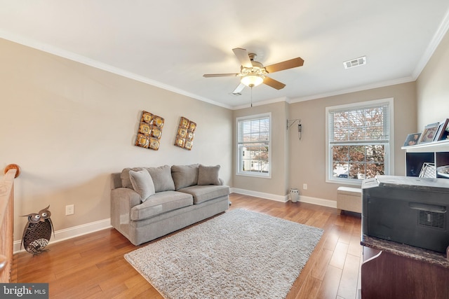 living room with light hardwood / wood-style floors, ceiling fan, and crown molding