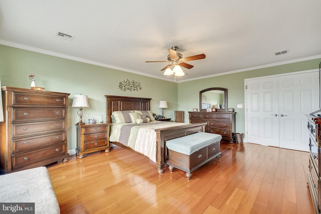 bedroom with wood-type flooring, a closet, ceiling fan, and ornamental molding