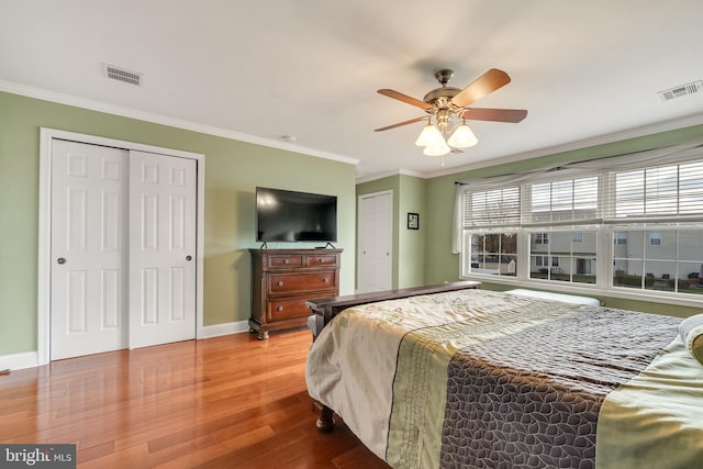 bedroom featuring ceiling fan, wood-type flooring, and ornamental molding